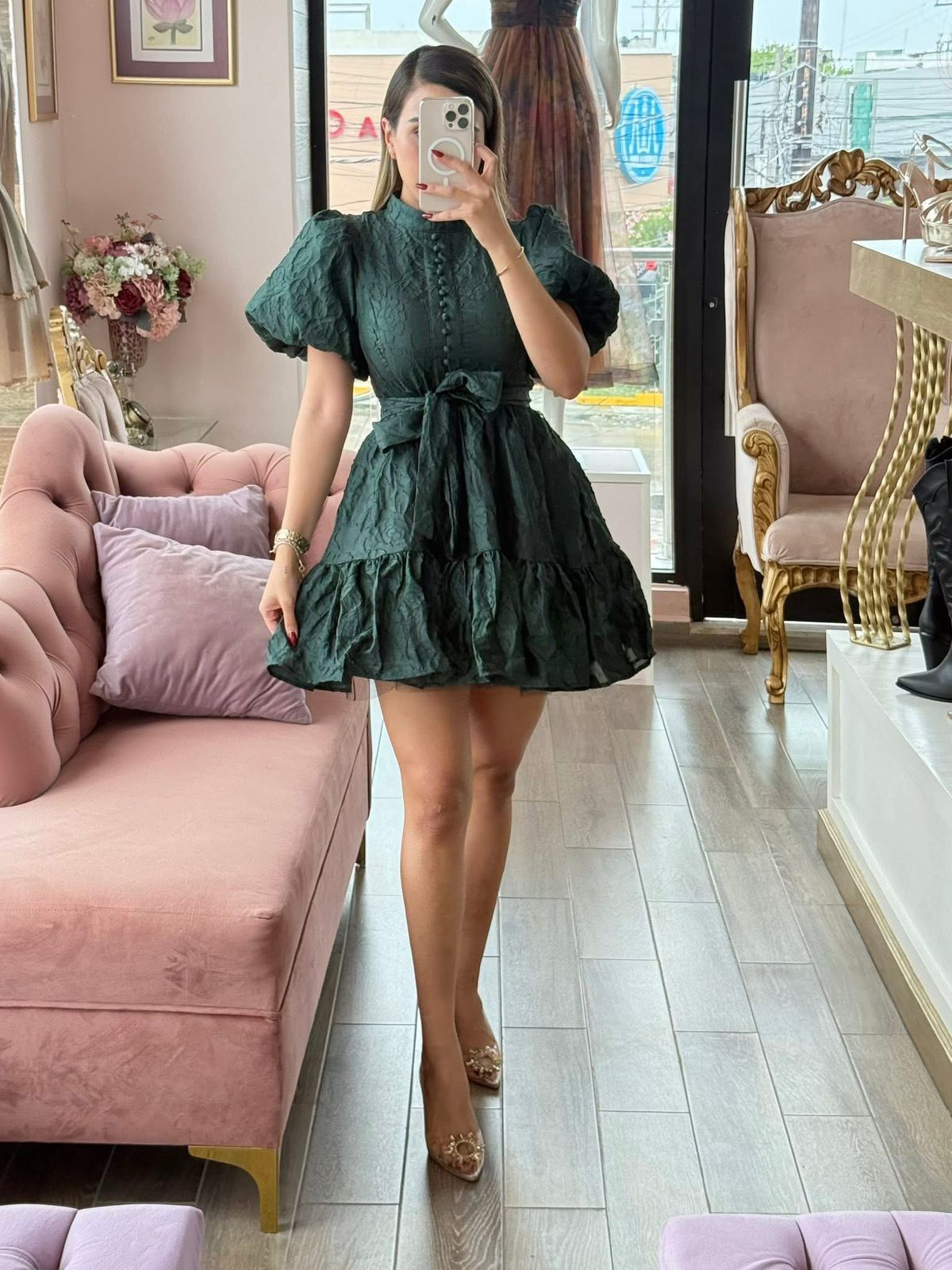 Vestido verde oscuro corto de tela corrugada con mangas abullonadas.